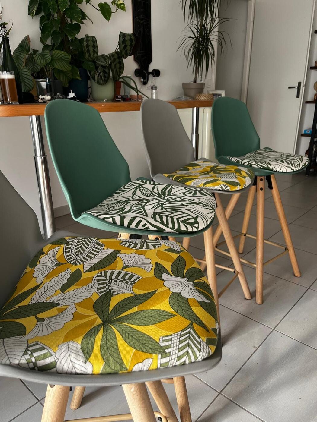 Chaises hautes avec des assises recouvertes de tissus à motif de feuillage