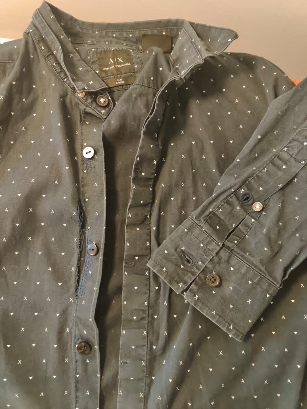 Chemise à pois dont la patte de boutonnage est usée