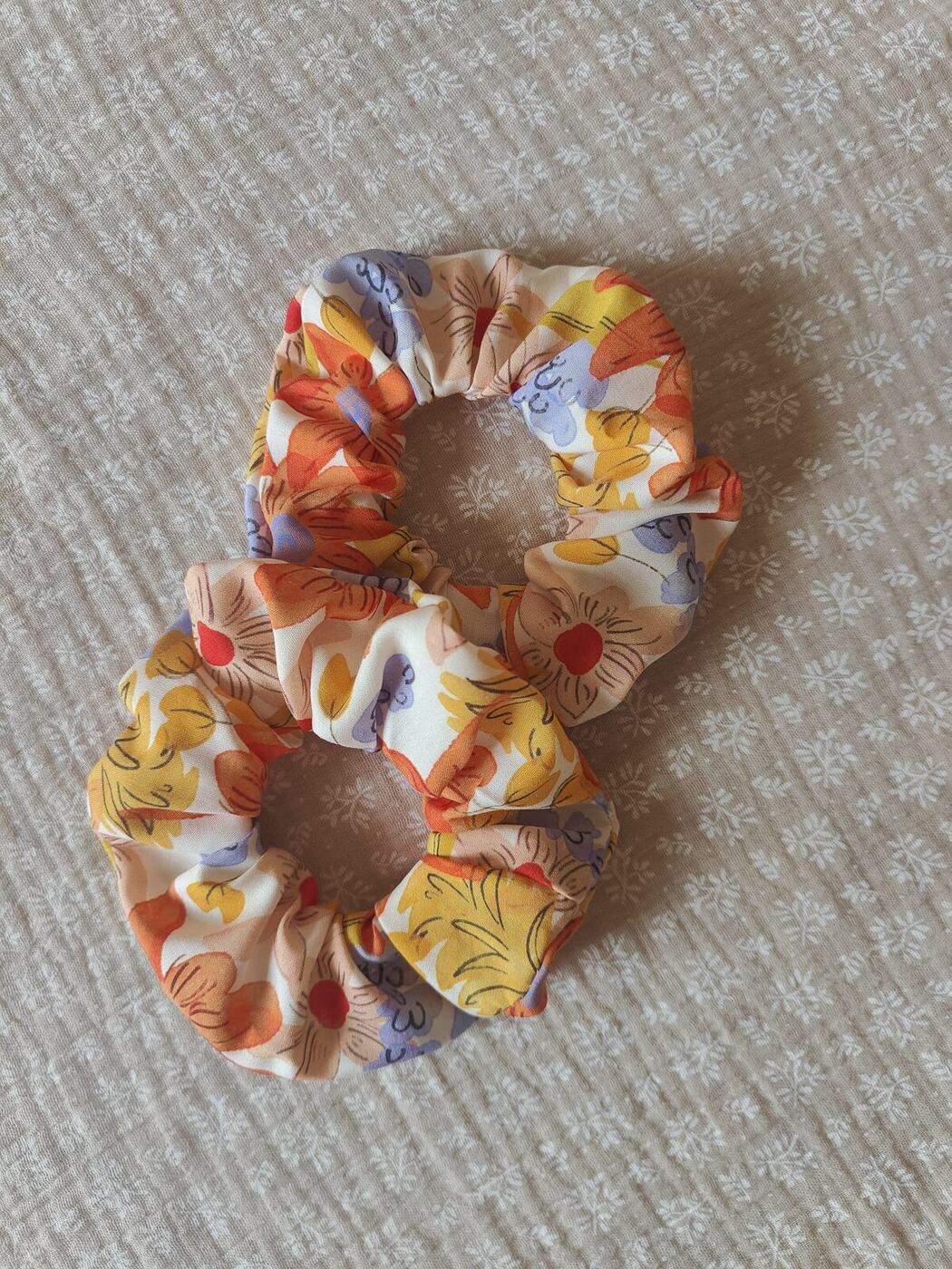 Deux chouchous en tissu à motif floral orange