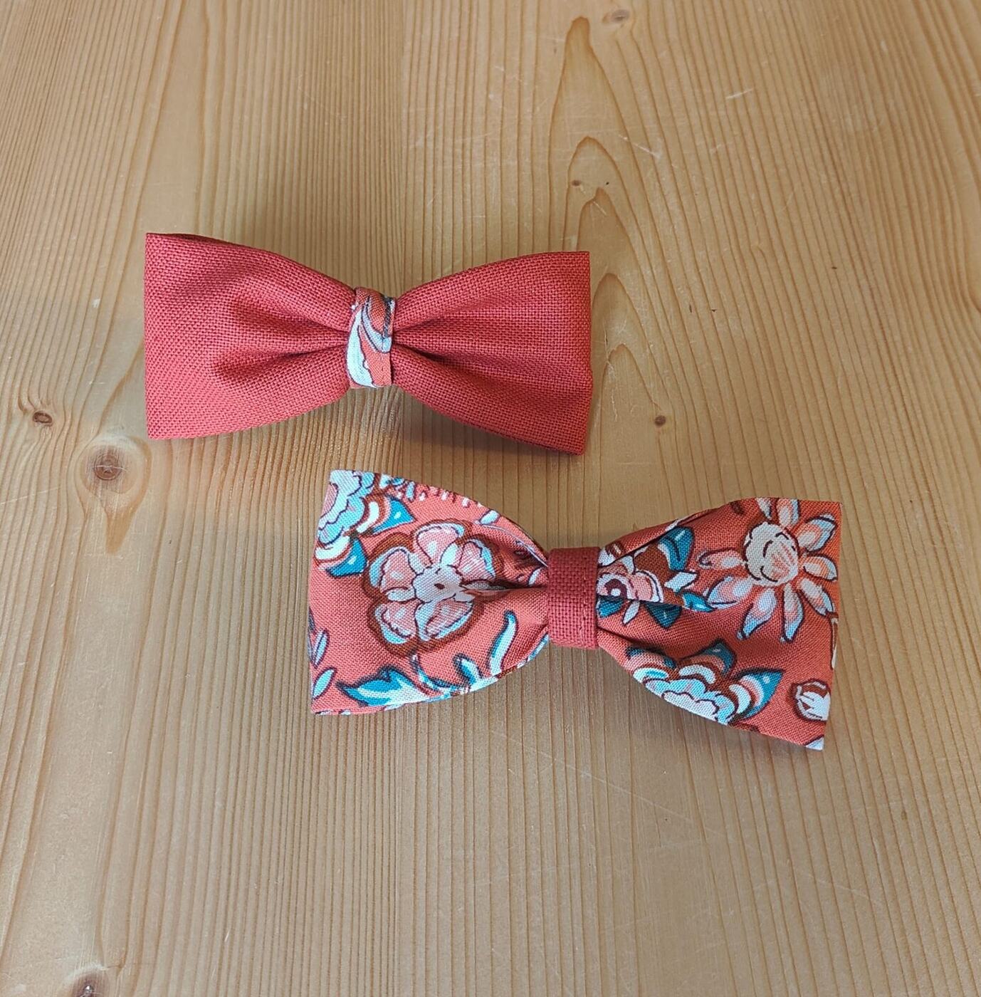 Deux nœuds papillon, l'un uni corail, l'autre à fleurs