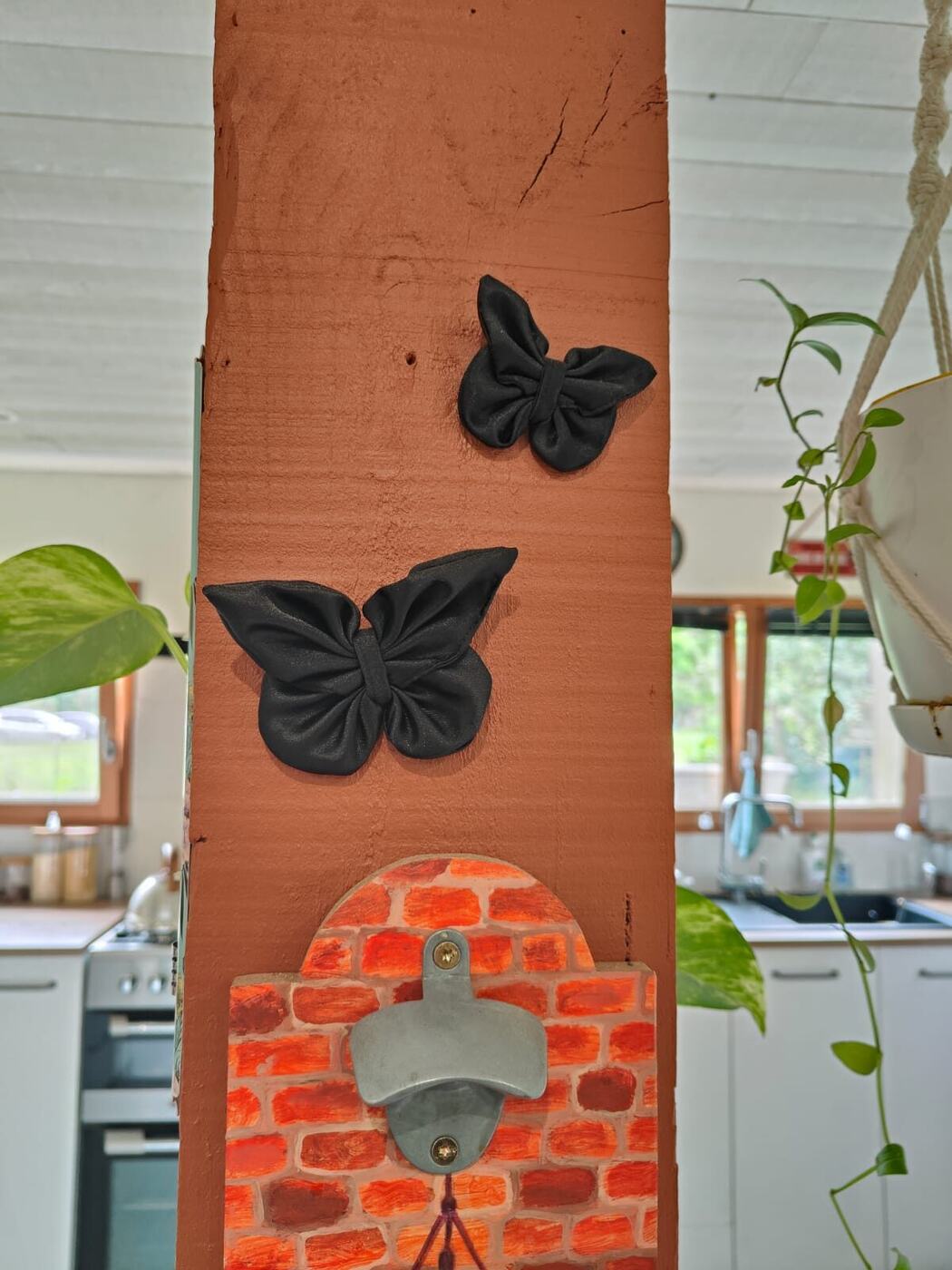 Deux papillons noirs en tissu fixés sur une poutre murale